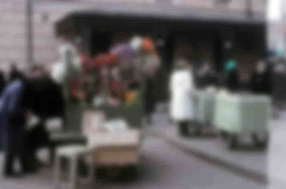Flowers and ice cream (in carts on right) for sale at an unknown location.